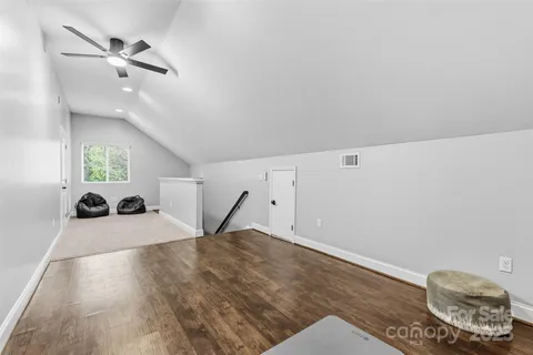 a view of a room with a ceiling fan and wooden floor