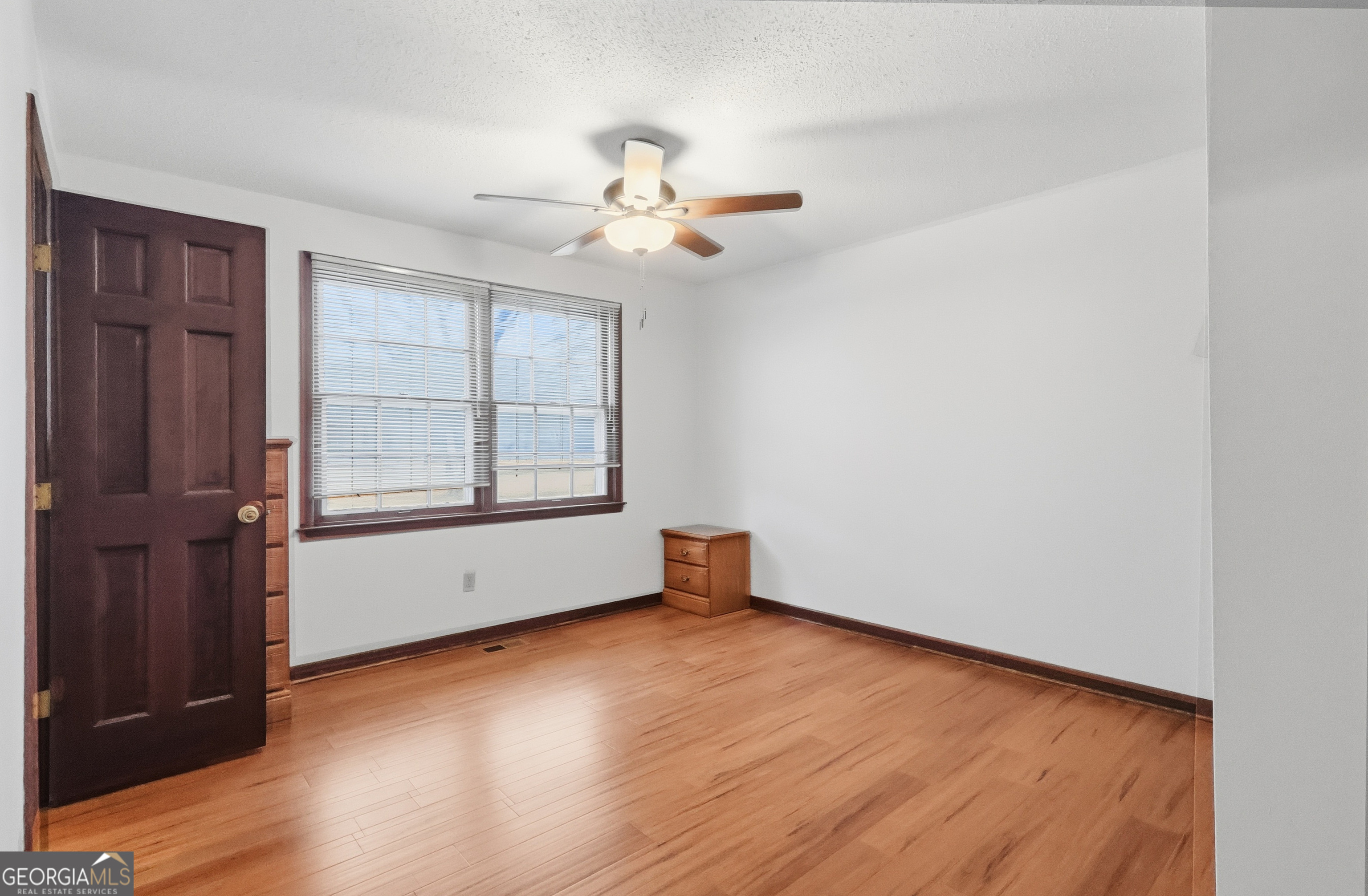 41 Brooks Street Royston, GA 30662 - Photo 16 of 44 an empty room with wooden floor chandelier fan and windows