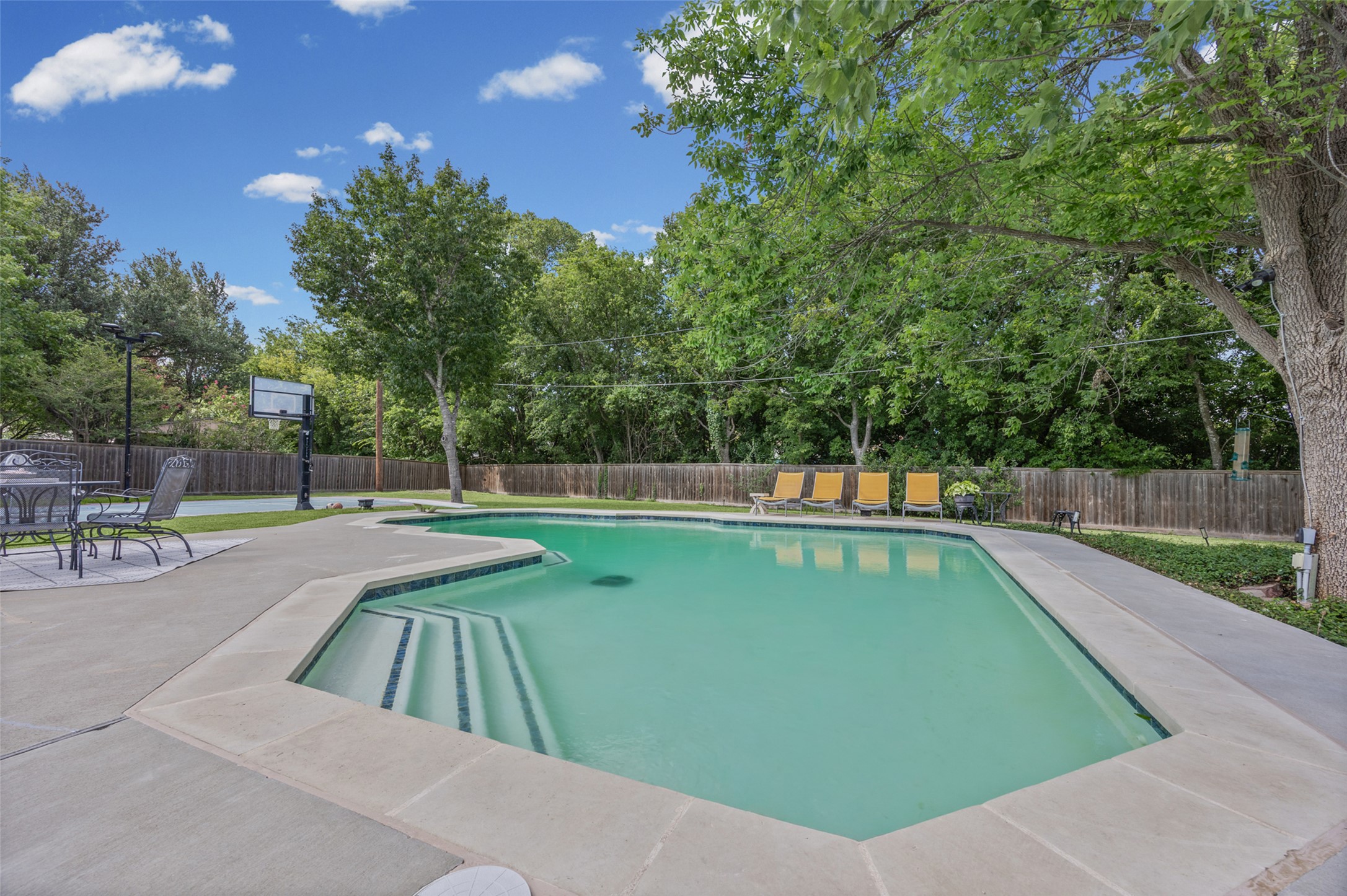 2000 Spinel Road Pflugerville, TX 78660 - Photo 25 of 31 A private backyard oasis features a shimmering pool, surrounded by mature trees, and a spacious concrete patio.