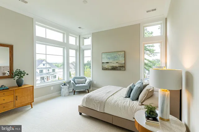 a spacious bedroom with a bed and glass window