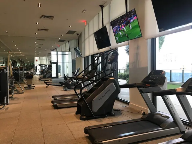 a living room with gym equipment and a flat screen tv