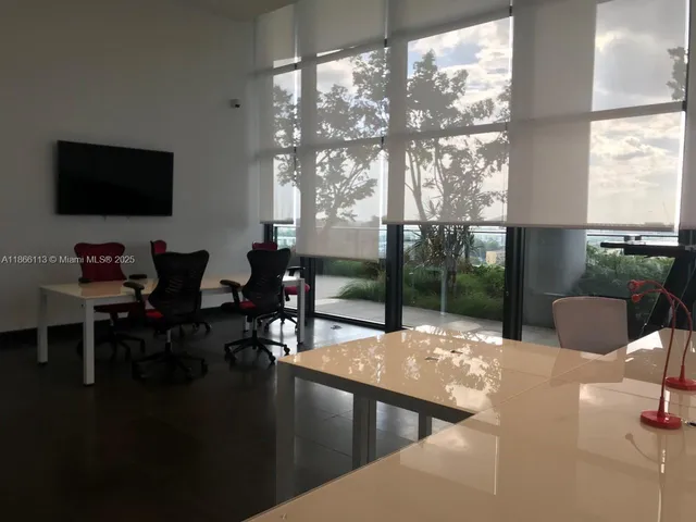 a living room with patio furniture and a floor to ceiling window