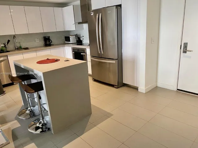 a kitchen with a refrigerator a stove a sink and cabinets