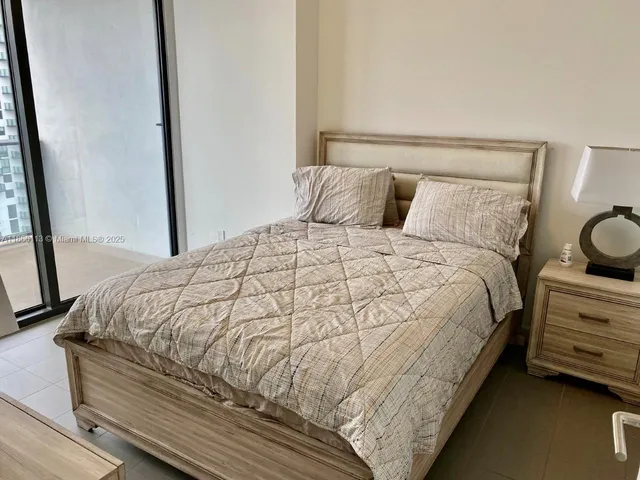 a large bed sitting in a bedroom next to a window