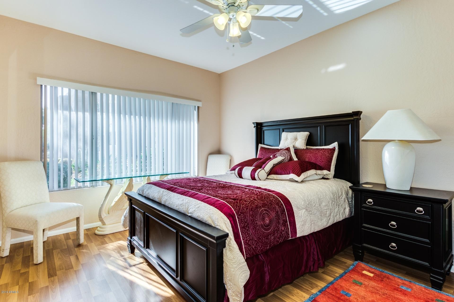 11260 North 92nd Street, Unit 1127 Scottsdale, AZ 85260 - Photo 11 of 42 a bedroom with a bed and a chandelier