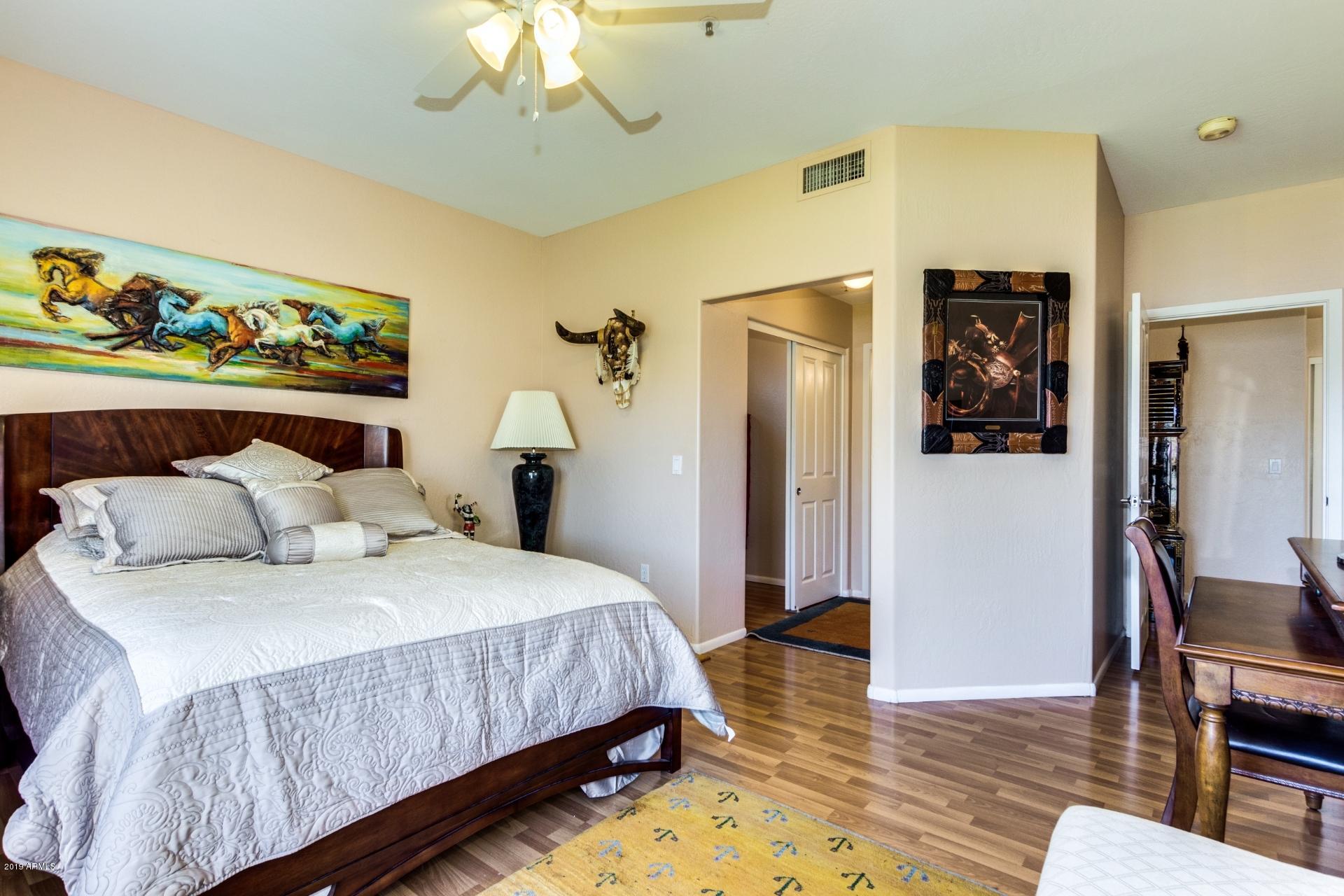11260 North 92nd Street, Unit 1127 Scottsdale, AZ 85260 - Photo 13 of 42 a bedroom with a bed and a chandelier