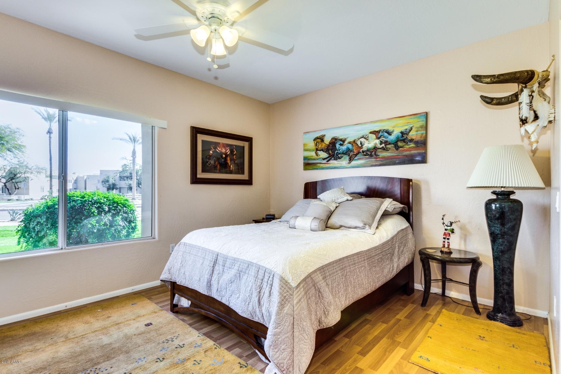 11260 North 92nd Street, Unit 1127 Scottsdale, AZ 85260 - Photo 14 of 42 a bedroom with a bed and a chandelier