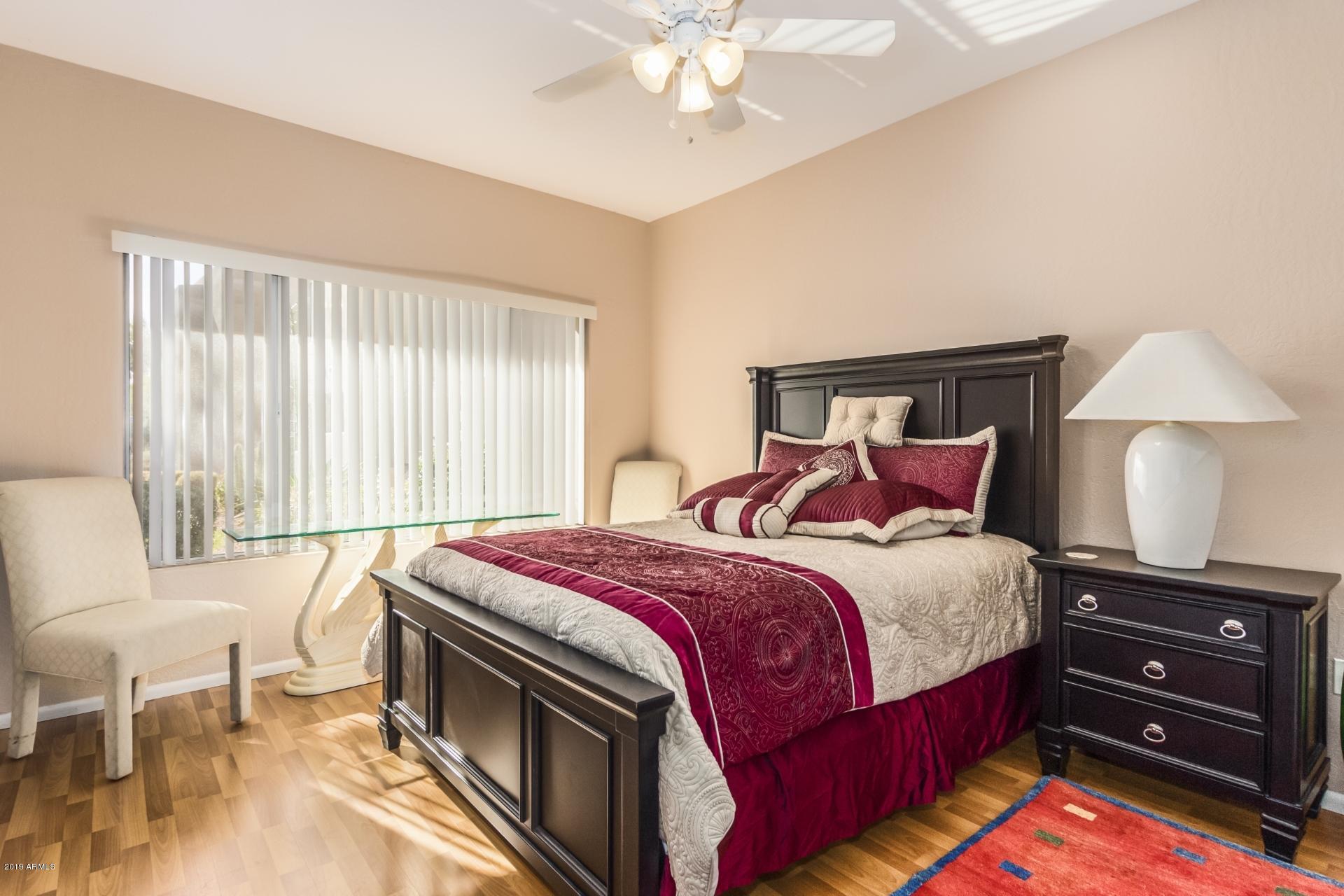 11260 North 92nd Street, Unit 1127 Scottsdale, AZ 85260 - Photo 16 of 42 a bedroom with a bed and a chandelier