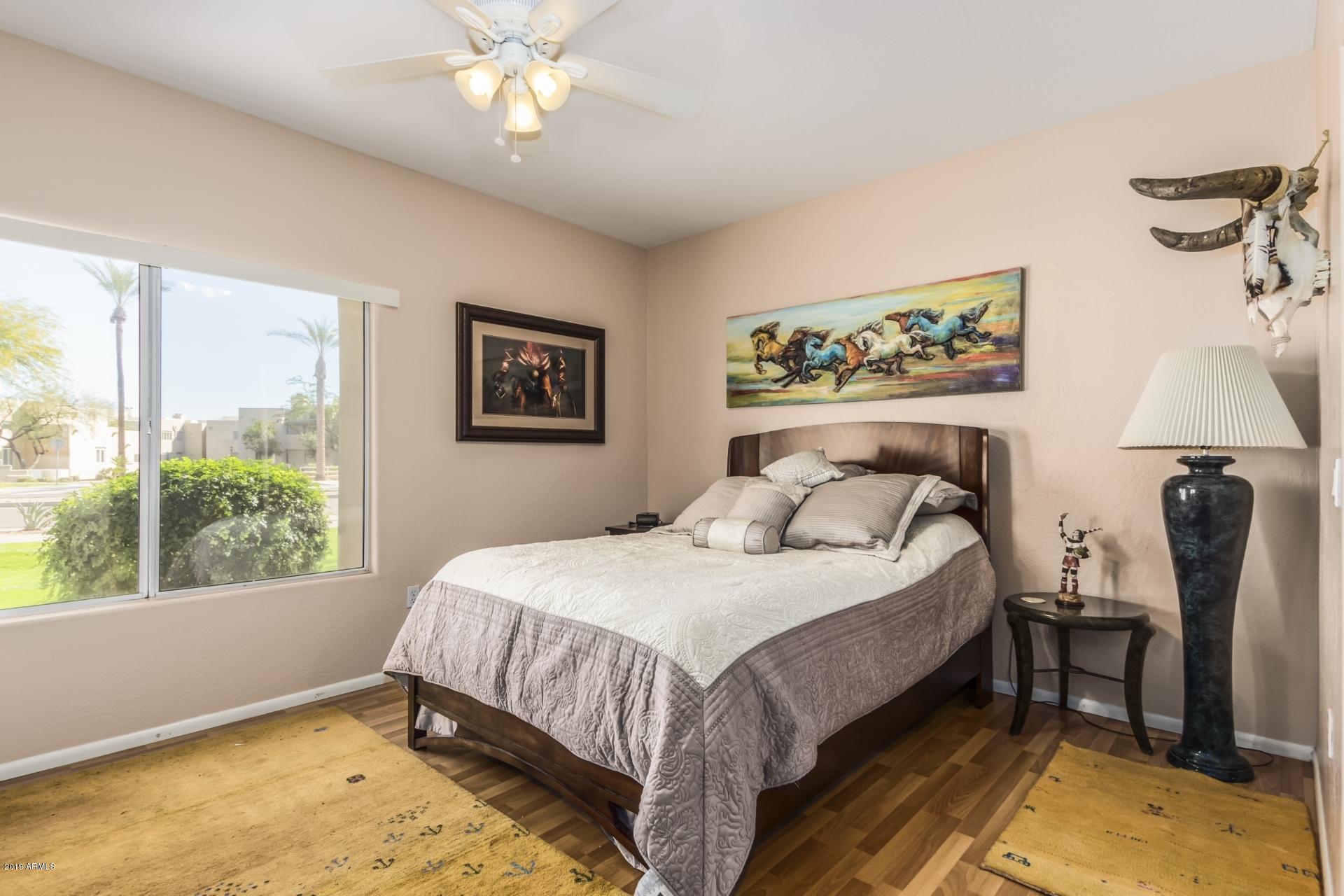 11260 North 92nd Street, Unit 1127 Scottsdale, AZ 85260 - Photo 18 of 42 a bedroom with a bed and a chandelier