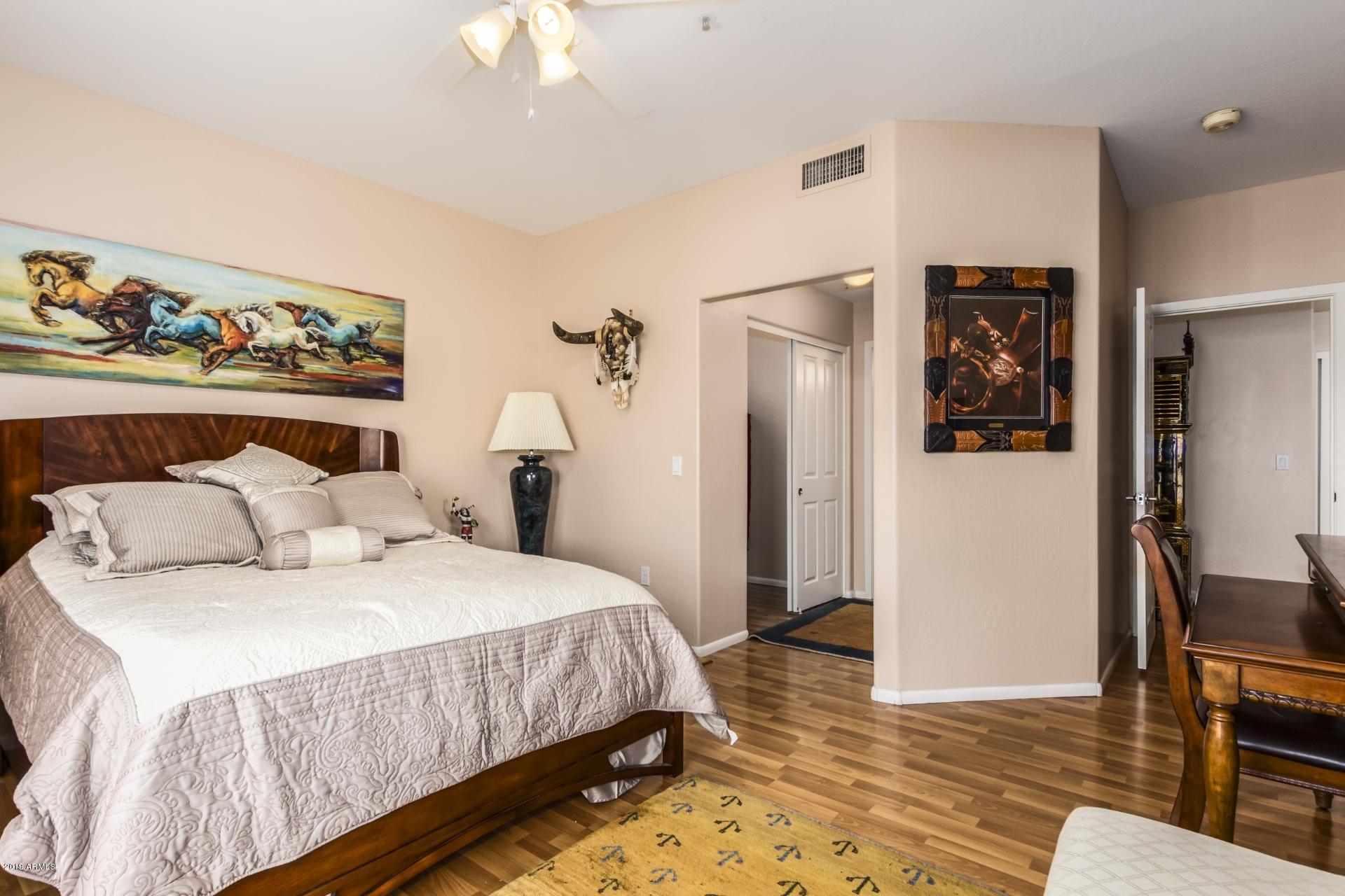 11260 North 92nd Street, Unit 1127 Scottsdale, AZ 85260 - Photo 19 of 42 a bedroom with a bed and a chandelier