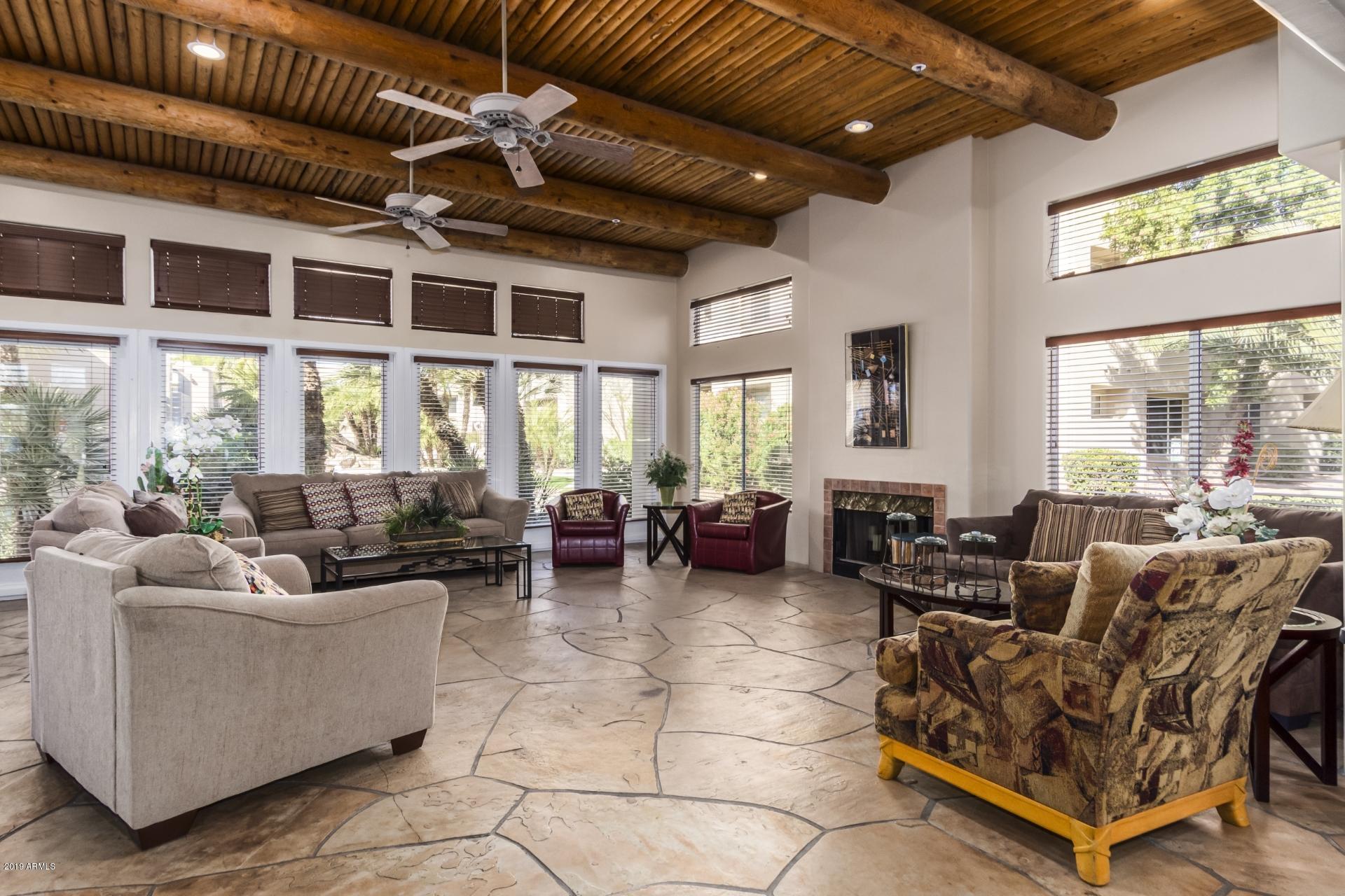 11260 North 92nd Street, Unit 1127 Scottsdale, AZ 85260 - Photo 30 of 42 a living room with furniture gym equipment and large windows