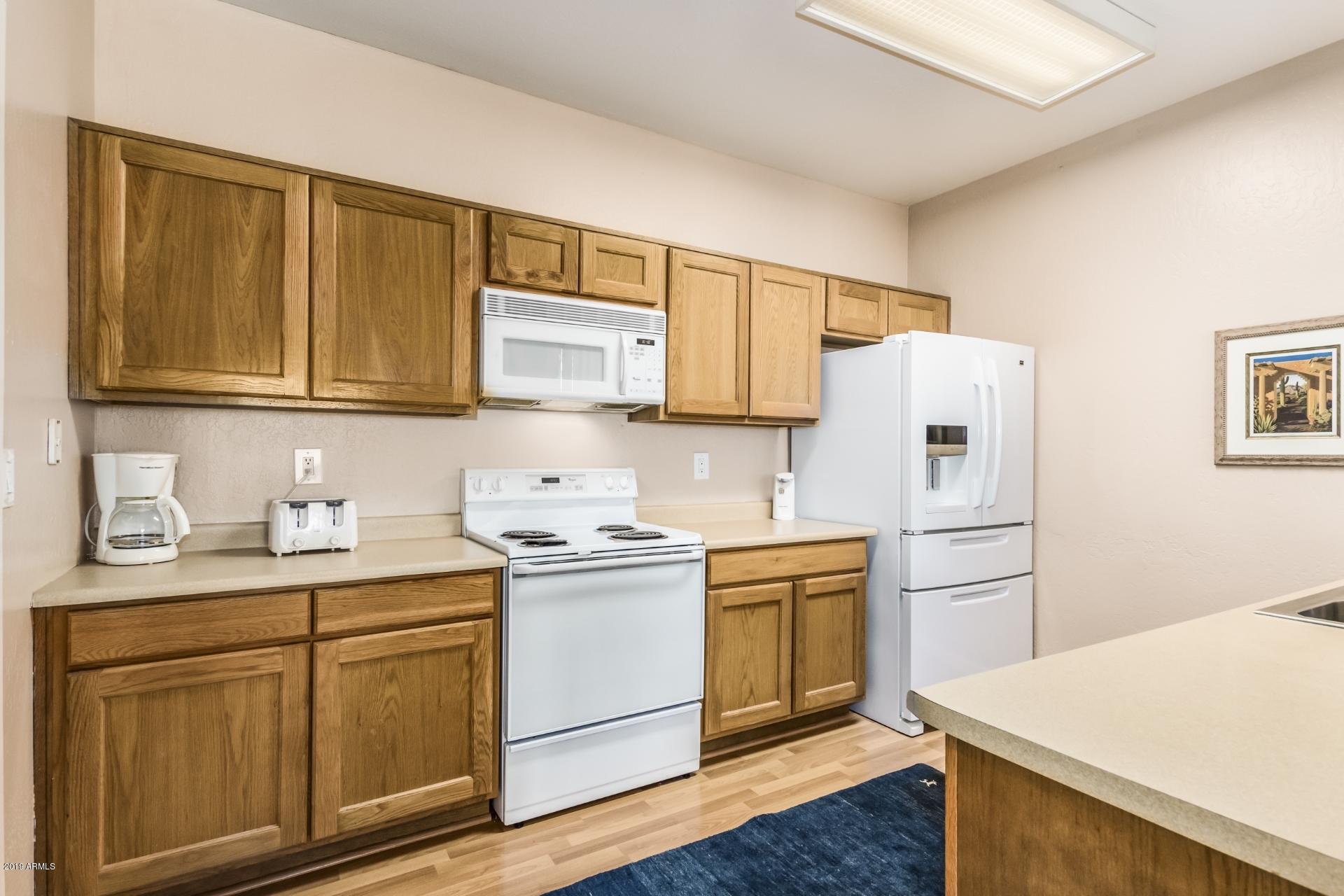 11260 North 92nd Street, Unit 1127 Scottsdale, AZ 85260 - Photo 6 of 42 a kitchen with stainless steel appliances a stove a refrigerator and cabinets