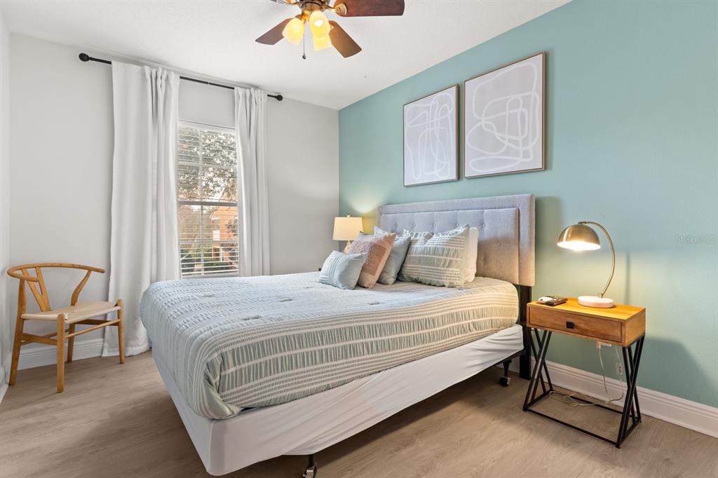 856 Assembly Court Reunion, FL 34747 - Photo 26 of 37 a bedroom with a bed a chair and a chandelier next to a window
