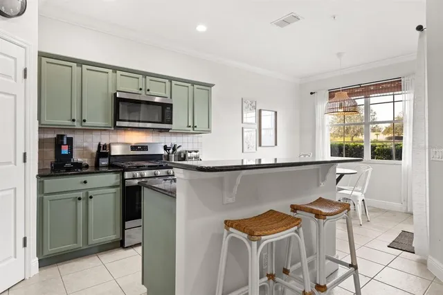 a kitchen with stainless steel appliances kitchen island granite countertop a sink and a stove top oven
