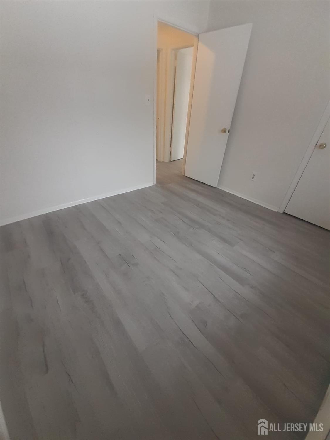 1776 Oak Tree Road Edison, NJ 08820 - Photo 6 of 9 an empty room with wooden floor