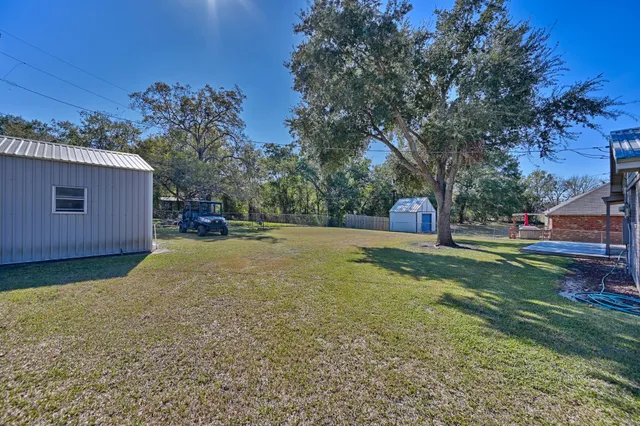 a view of a house with a yard and tree s