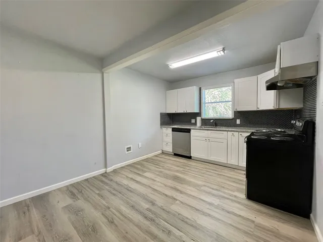 a kitchen with granite countertop a refrigerator stove top oven and sink