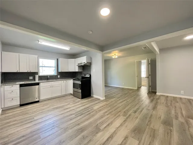 a large kitchen with granite countertop a large counter top stainless steel appliances and cabinets