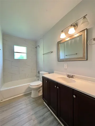 a bathroom with a toilet a sink a bathtub and a mirror