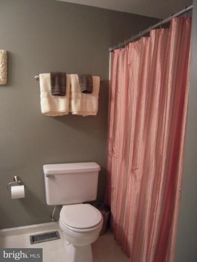 17317 Soper Street Poolesville, MD 20837 - Photo 20 of 29 a white toilet sitting next to a shower curtain