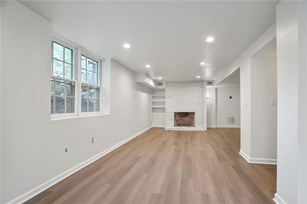 4555 Runnemede Road Northwest Atlanta, GA 30327 - Photo 27 of 51 a view of empty room with wooden floor and fireplace
