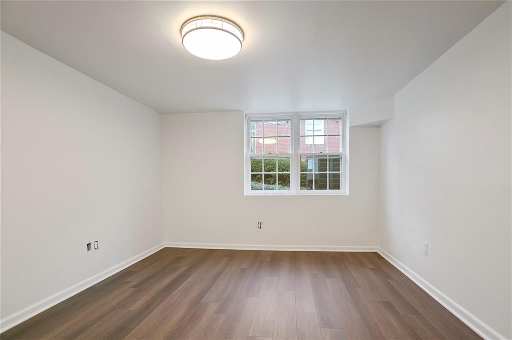 4555 Runnemede Road Northwest Atlanta, GA 30327 - Photo 28 of 51 an empty room with wooden floor and windows