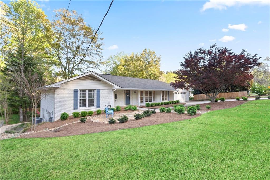 4555 Runnemede Road Northwest Atlanta, GA 30327 - Photo 3 of 51 a front view of a house with a garden and trees