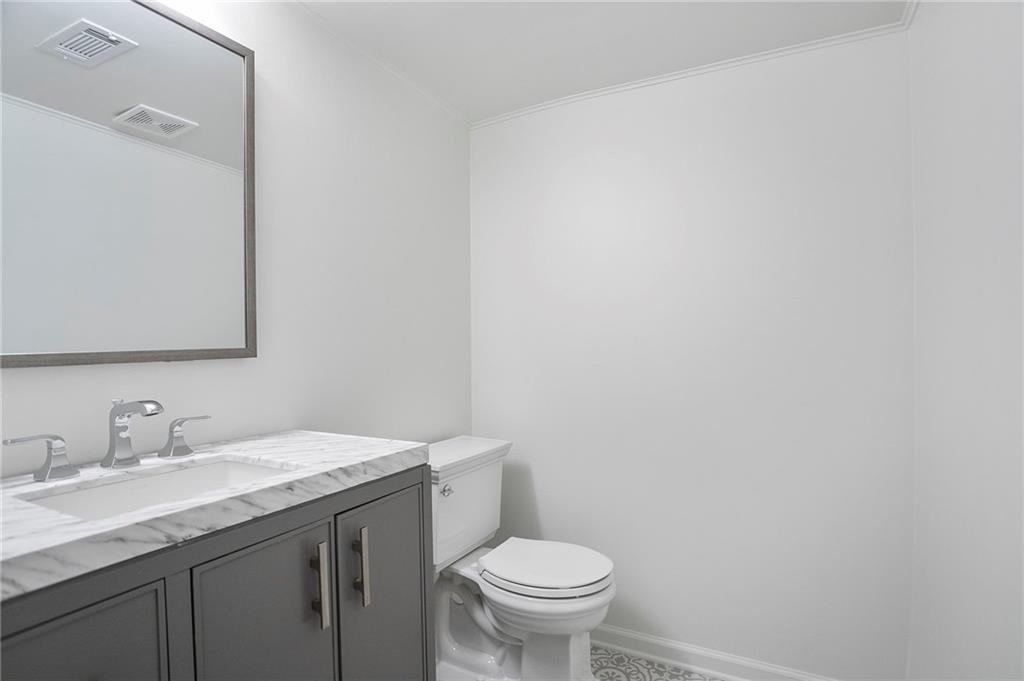 4555 Runnemede Road Northwest Atlanta, GA 30327 - Photo 32 of 51 a bathroom with a granite countertop toilet a sink and a mirror