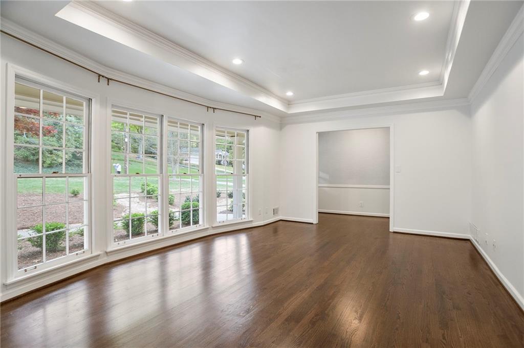 4555 Runnemede Road Northwest Atlanta, GA 30327 - Photo 7 of 51 a view of empty room with wooden floor and fan