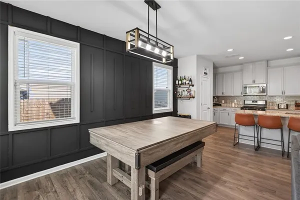 a open kitchen with a table chairs and wooden floor