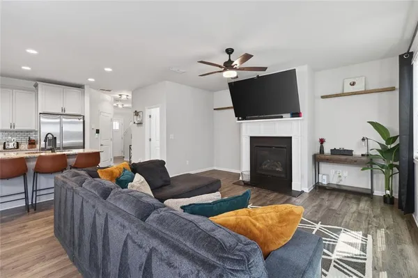 a living room with furniture a flat screen tv and a fireplace