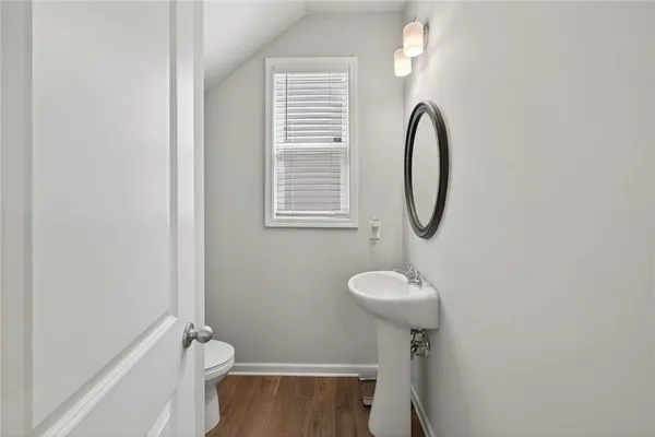 a bathroom with a sink toilet and a mirror
