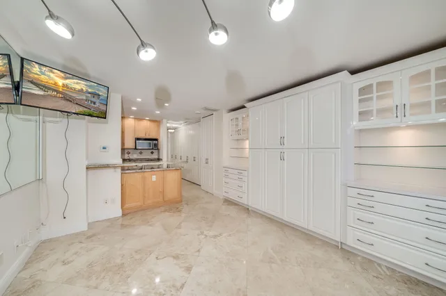 a large white kitchen with white cabinets and stainless steel appliances