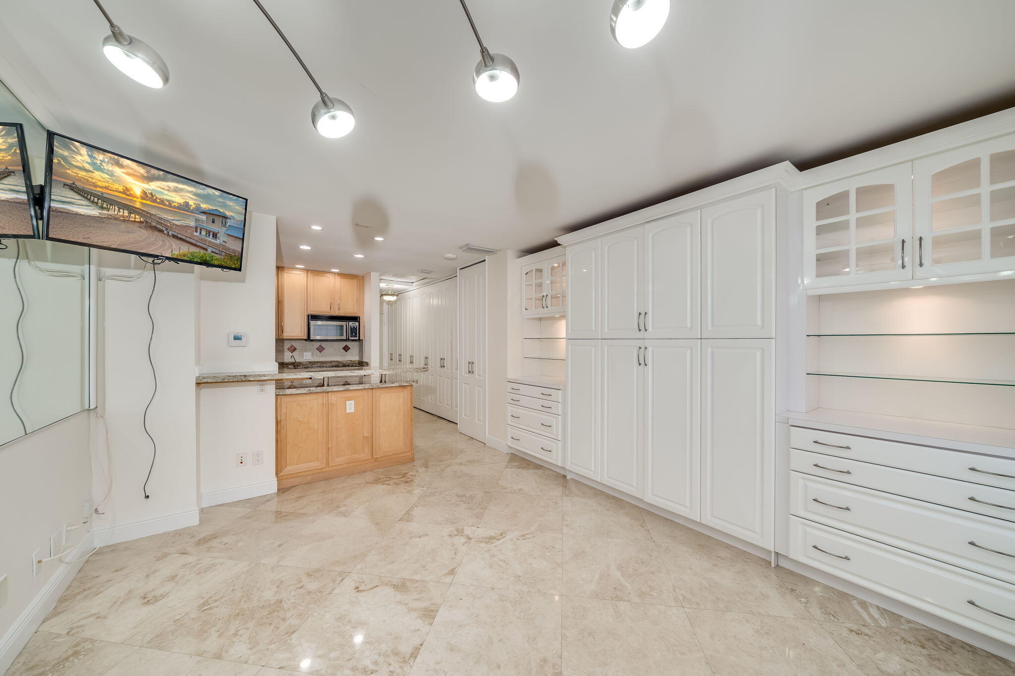 a large white kitchen with white cabinets and stainless steel appliances