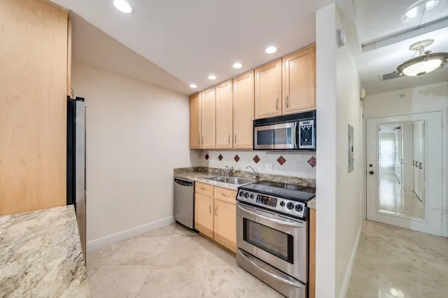 a kitchen with stainless steel appliances granite countertop a stove and a refrigerator