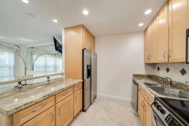 a kitchen with granite countertop white cabinets and stainless steel appliances