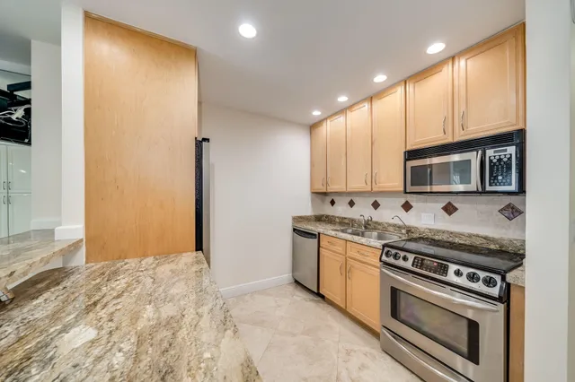a kitchen with stainless steel appliances granite countertop a refrigerator and a sink