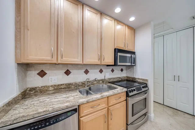 a bathroom with a granite countertop sink a mirror and a shower