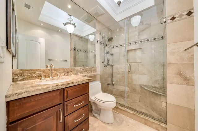 a bathroom with a granite countertop sink a toilet and mirror