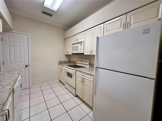a kitchen with a refrigerator sink stove and cabinets