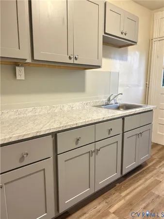 a kitchen with granite countertop white cabinets and a sink
