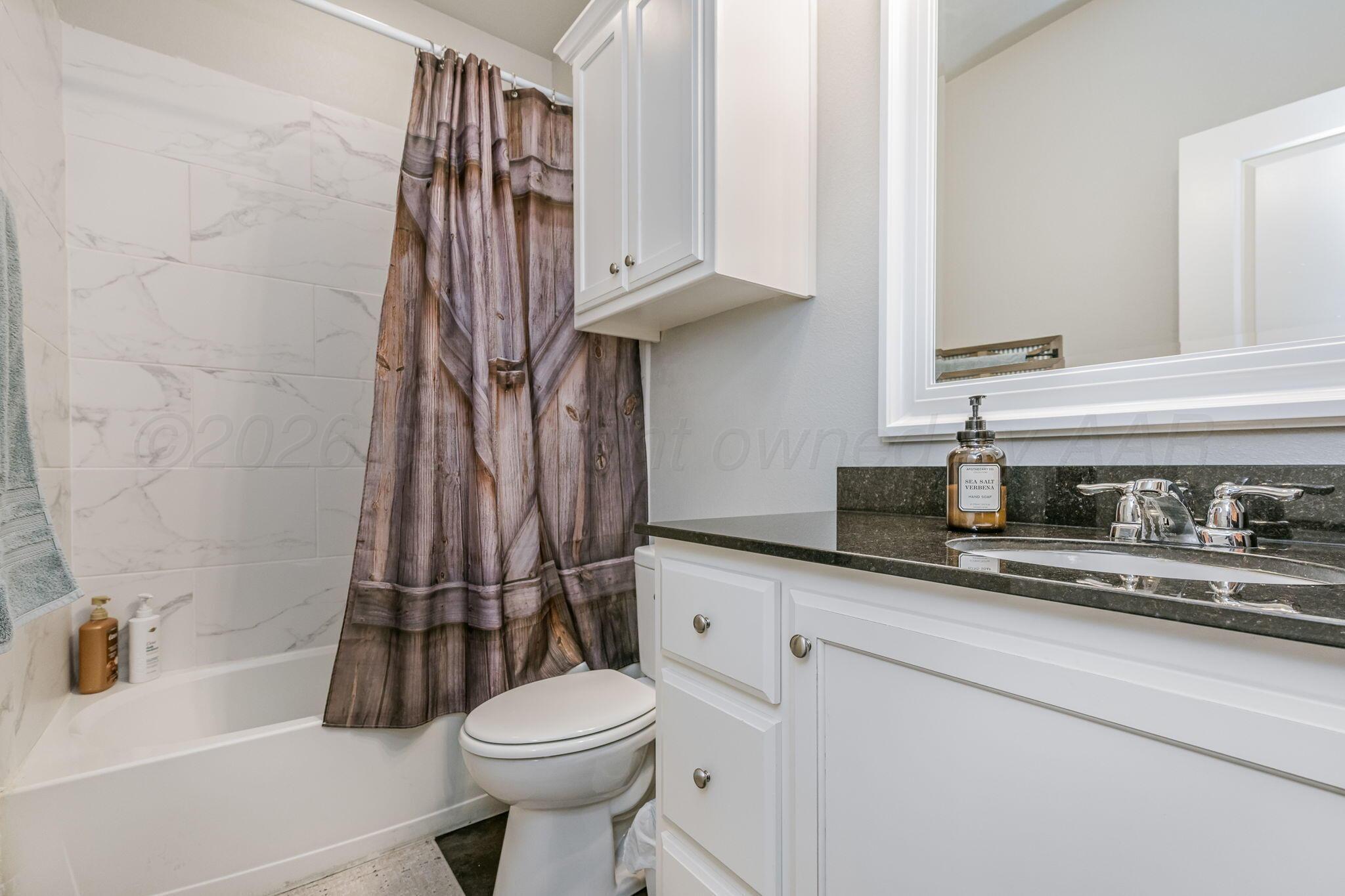 4700 Longbird Street Amarillo, TX 79118 - Photo 14 of 23 a bathroom with a granite countertop sink a toilet and a bathtub