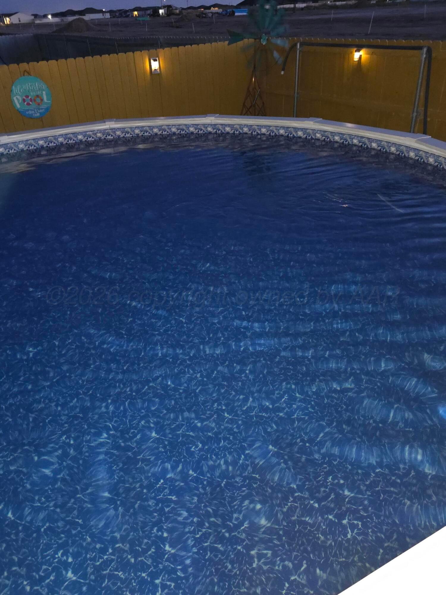 4700 Longbird Street Amarillo, TX 79118 - Photo 22 of 23 a view of a swimming pool with a yard and a large tree