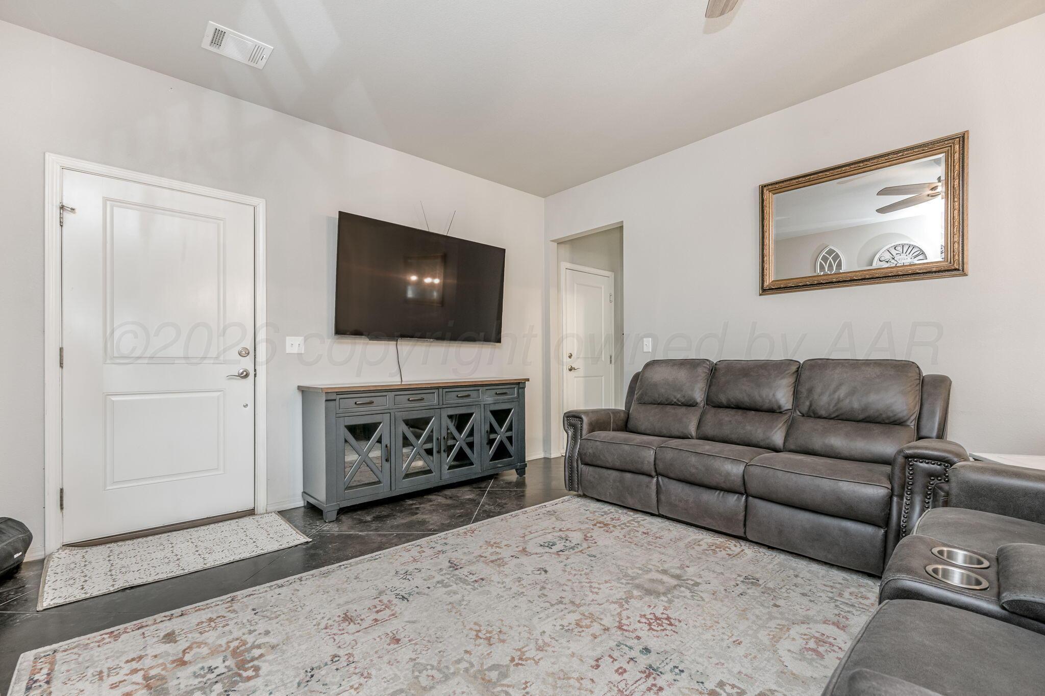 4700 Longbird Street Amarillo, TX 79118 - Photo 4 of 23 a living room with furniture a fireplace and a flat screen tv