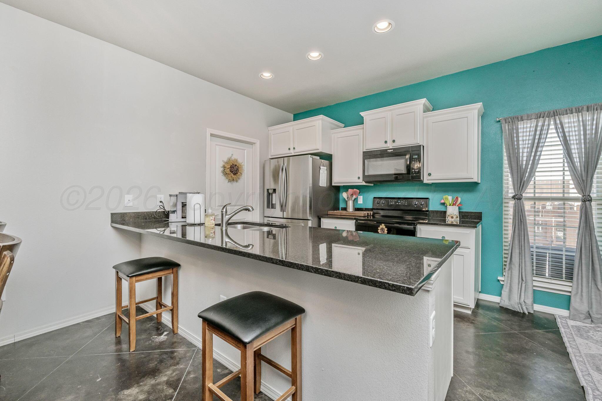 4700 Longbird Street Amarillo, TX 79118 - Photo 7 of 23 a kitchen with stainless steel appliances granite countertop a sink stove and refrigerator