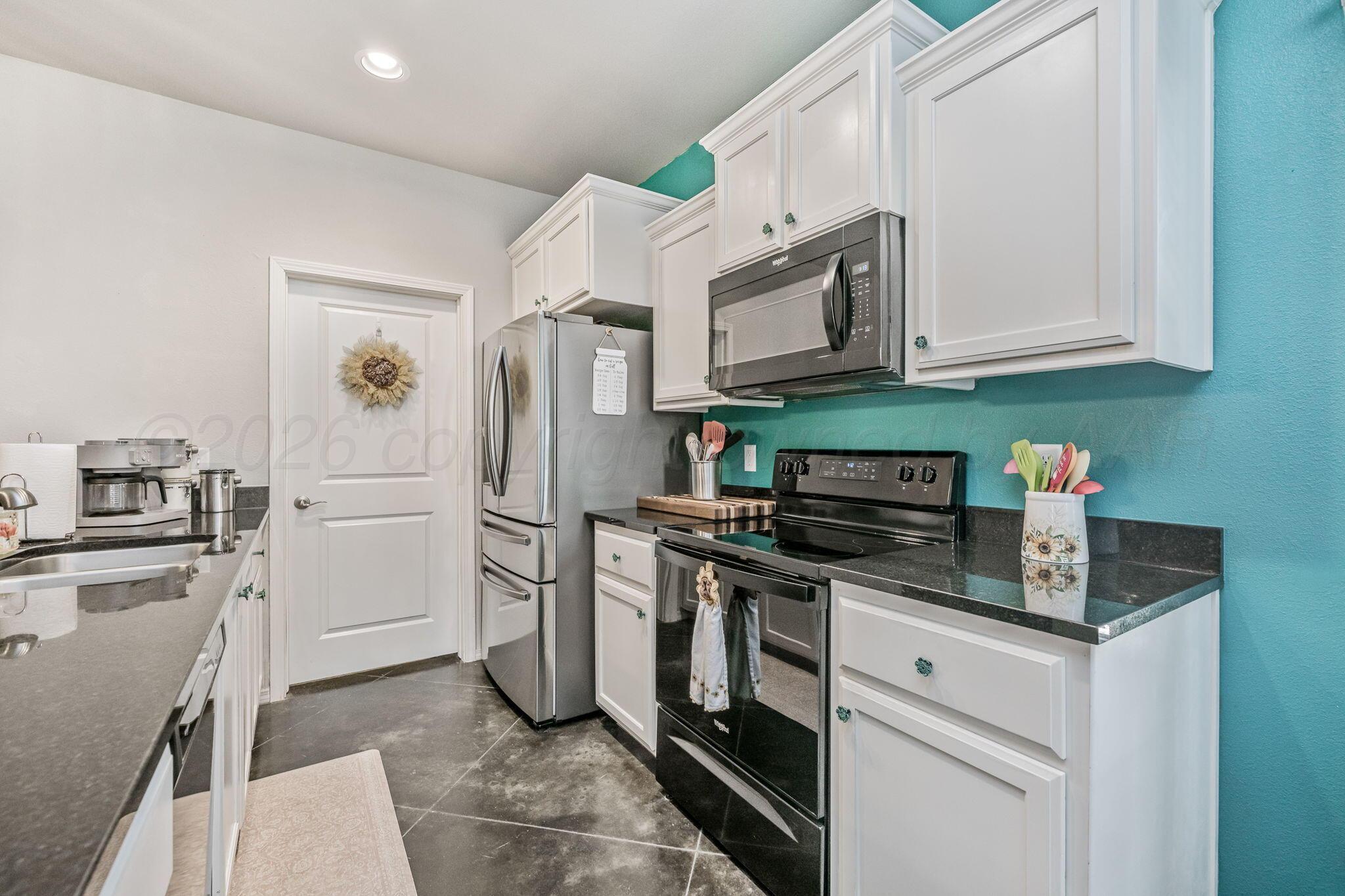 4700 Longbird Street Amarillo, TX 79118 - Photo 8 of 23 a kitchen with stainless steel appliances granite countertop a refrigerator sink and stove