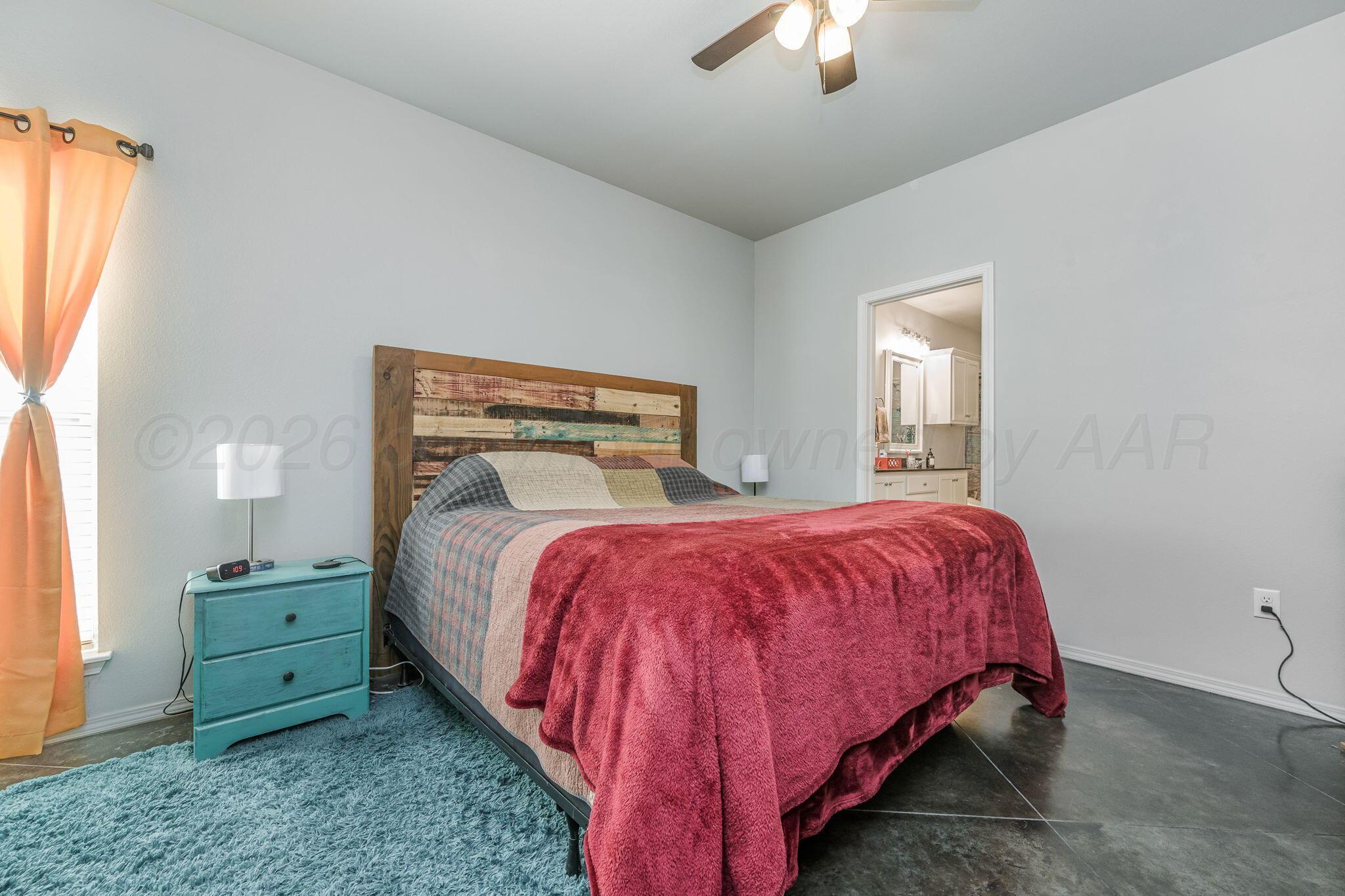 4700 Longbird Street Amarillo, TX 79118 - Photo 10 of 23 a bed sitting in a bedroom next to a window and a chandelier