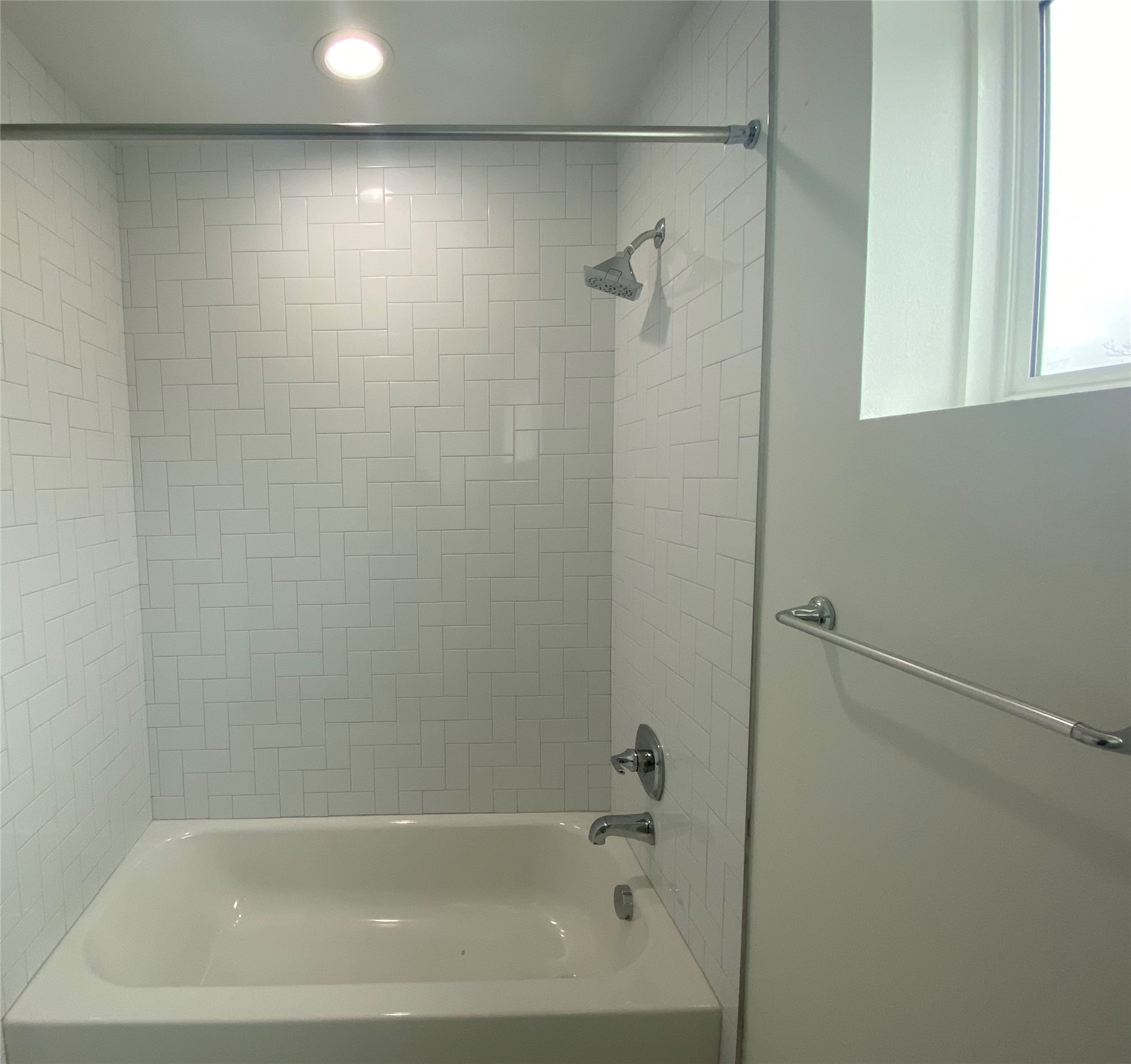 1916 Webberville Road, Unit B Austin, TX 78721 - Photo 21 of 25 Bathtub and shower combination featuring white herringbone tile surround, recessed lighting, and chrome fixtures