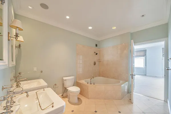 a bathroom with a granite countertop bathtub sink vanity mirror and toilet