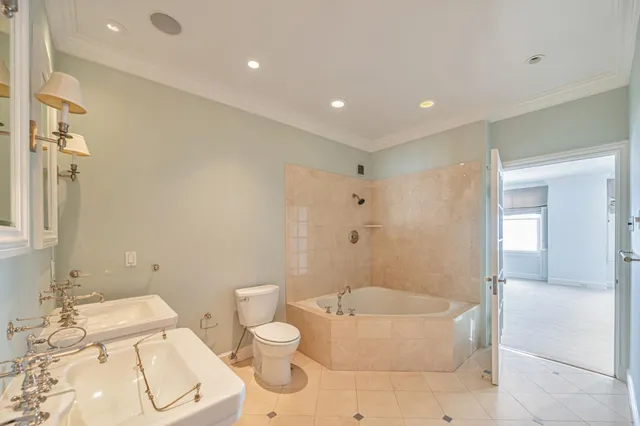 a bathroom with a granite countertop bathtub sink vanity mirror and toilet